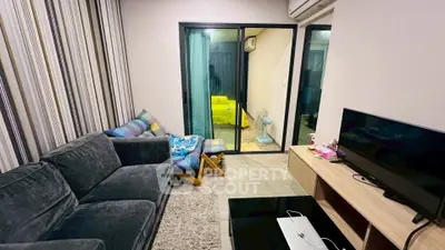 Cozy living room with modern decor and sliding glass doors leading to a balcony.