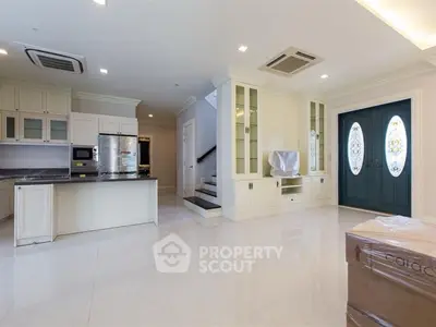 Spacious modern living room with open kitchen and elegant staircase