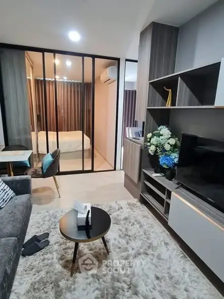 Modern living room with cozy decor and view into a stylish bedroom