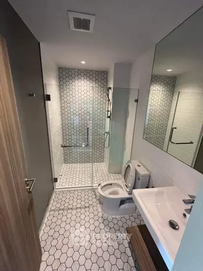 Modern bathroom with hexagonal tiles and glass shower enclosure