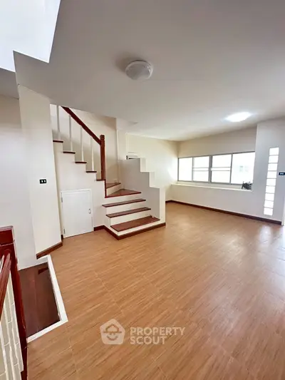 Spacious modern living room with wooden flooring and staircase