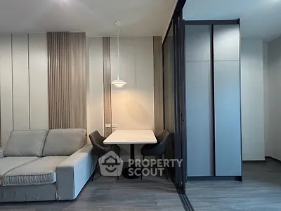 Modern living room with cozy sofa and dining area, featuring sleek design and stylish lighting.