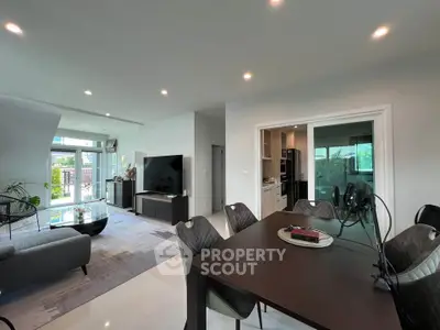 Spacious modern living and dining area with sleek furniture and large windows for natural light.
