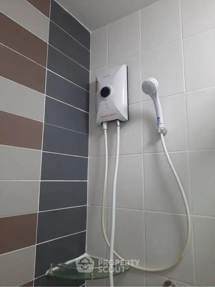 Modern bathroom with sleek showerhead and water heater, featuring stylish tile design.