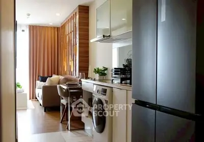 Modern apartment with sleek kitchen and cozy living area, featuring stylish decor and natural light.