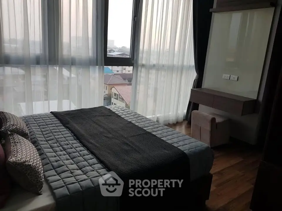 Modern bedroom with large windows and stylish decor in a high-rise apartment.