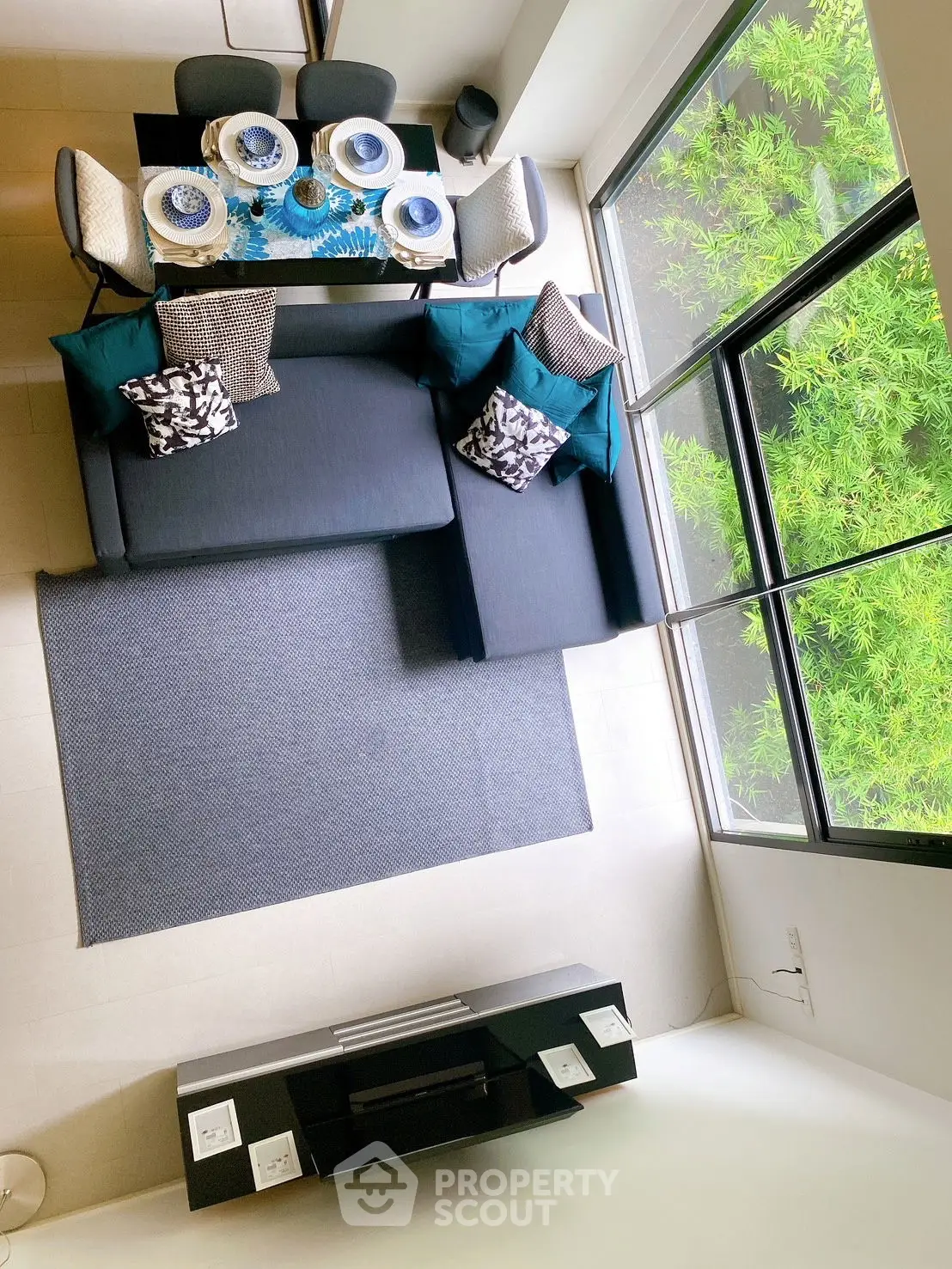 Modern living room with stylish dining area and large window view of greenery.