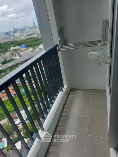 High-rise balcony with city view and drying rack, perfect for urban living.