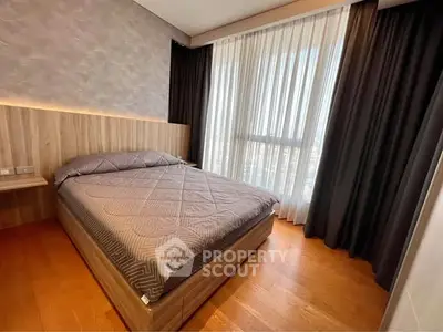 Modern bedroom with large window and stylish wooden flooring