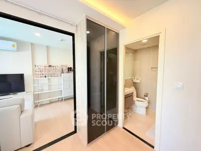 Modern apartment interior with living room and bathroom, featuring sleek design and ample natural light.