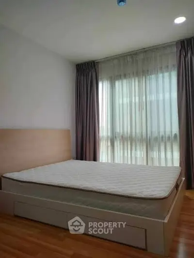 Spacious bedroom with large window and elegant curtains in modern apartment