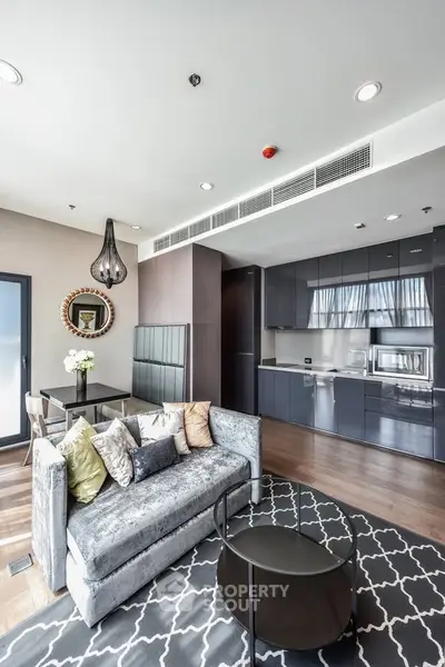 Modern living room with open kitchen, stylish decor, and ample natural light in a luxury apartment.