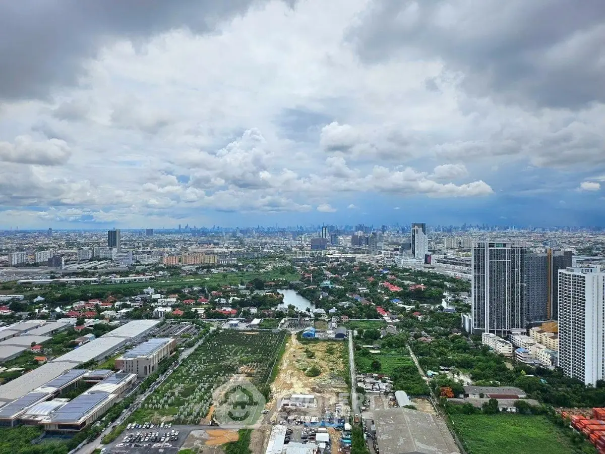 Stunning panoramic cityscape view from high-rise building showcasing urban and green landscapes.