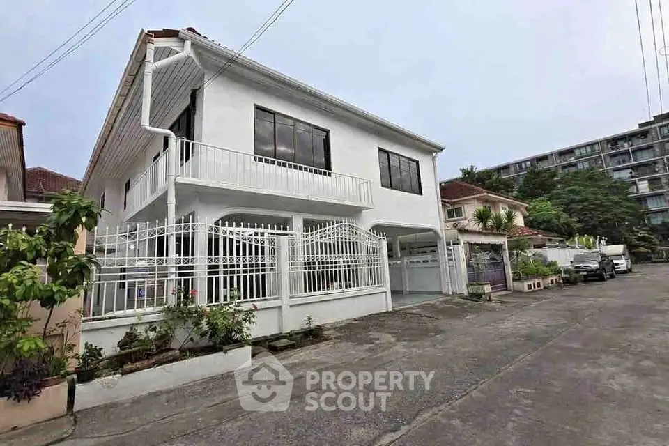 Charming two-story white house with gated entrance in a serene neighborhood, perfect for family living.