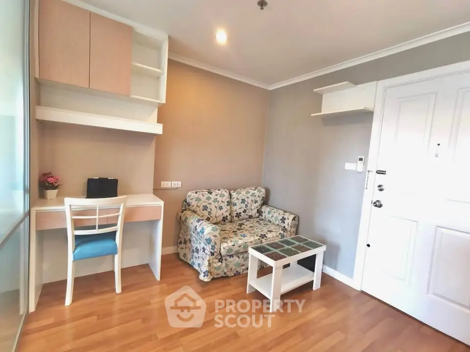 Cozy living room with floral sofa and study desk in modern apartment