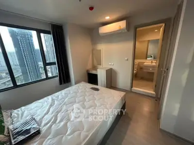 Modern bedroom with city view and ensuite bathroom in high-rise apartment