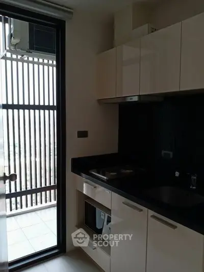 Modern kitchen with sleek cabinets and balcony access