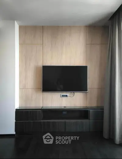 Modern living room with sleek TV setup and elegant wood paneling.