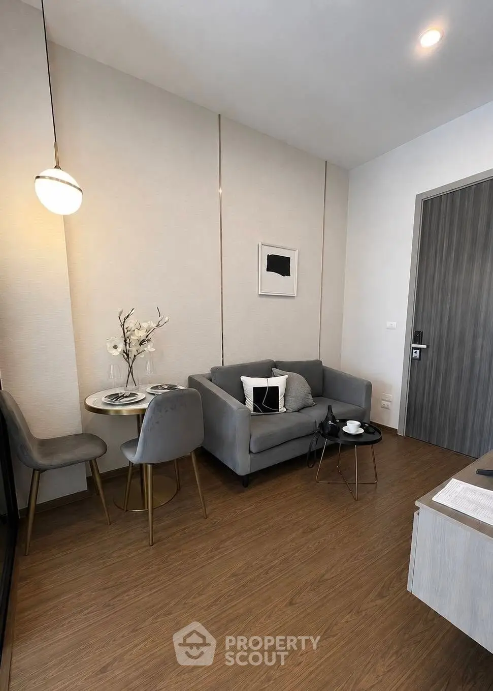 Modern living room with stylish gray sofa, elegant dining set, and chic decor in a cozy apartment.