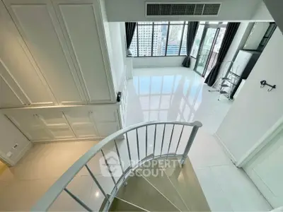 Spacious modern duplex with large windows and city view, featuring sleek staircase and bright interiors.