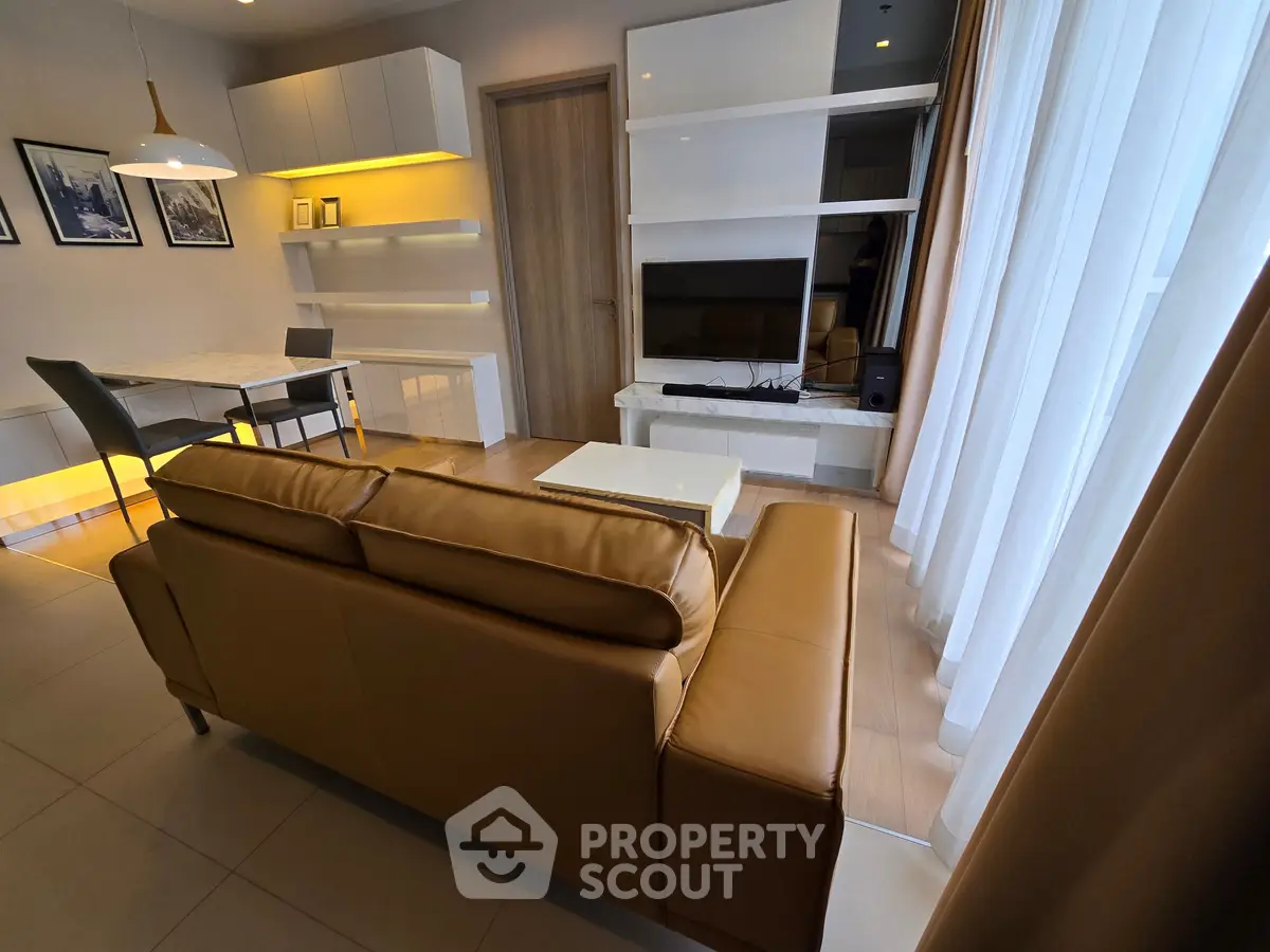 Modern living room with sleek furniture and natural light, perfect for relaxation and entertainment.