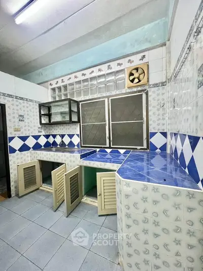Charming kitchen with unique tile design and ample storage space, perfect for culinary enthusiasts.