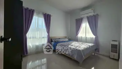 Spacious bedroom with natural light, modern decor, and air conditioning, perfect for comfort and relaxation.