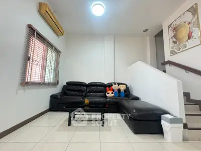 Modern living room with black leather sofa and stylish decor