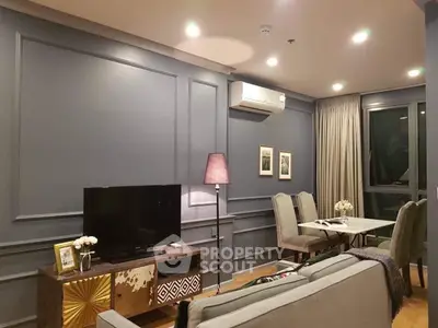 Elegant living room with modern decor, featuring a cozy dining area and stylish lighting.