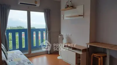 Charming living room with balcony and scenic view, featuring modern decor and natural light.
