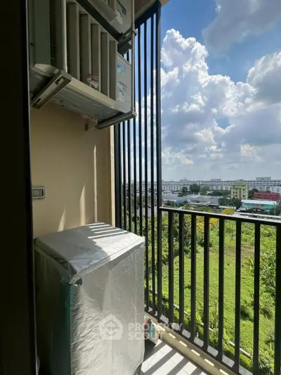 Charming balcony with lush green view and air conditioning unit, perfect for relaxation.