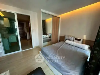 Modern bedroom with mirrored closet and ambient lighting in a stylish apartment.