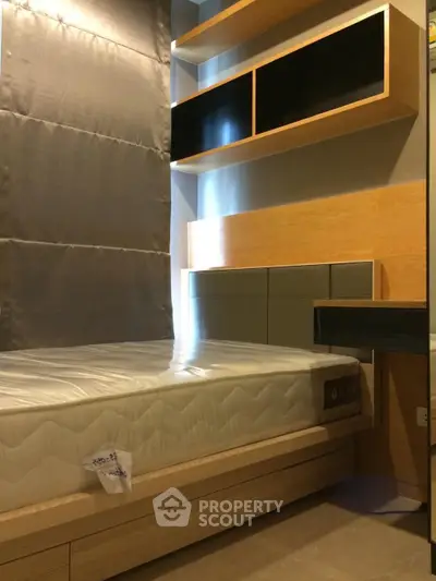 Modern bedroom with sleek shelving and comfortable mattress in stylish apartment.