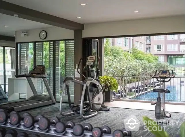 Modern gym with pool view in luxury apartment complex