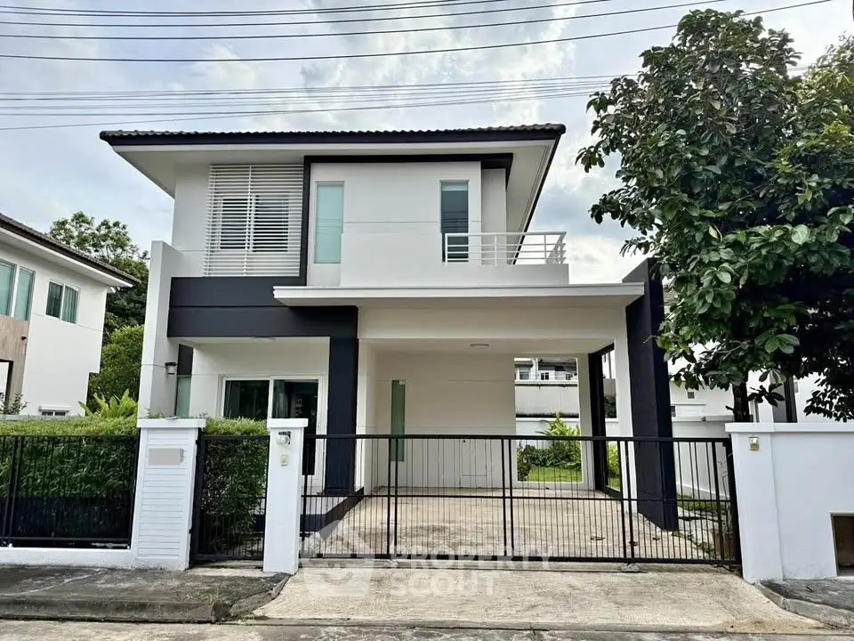 Modern two-story house with sleek design and spacious driveway in a serene neighborhood.