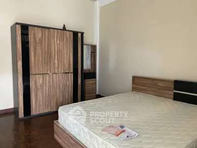 Spacious bedroom with modern wooden wardrobe and comfortable bed