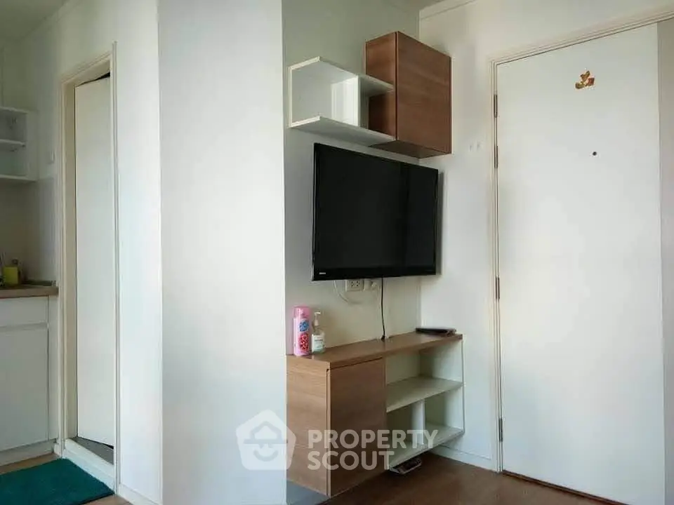 Modern apartment interior with wall-mounted TV and stylish storage units.
