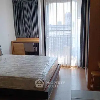 Bright bedroom with large window and modern furniture in city apartment