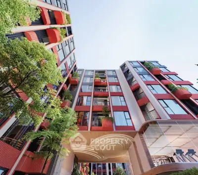 Modern architectural building with vibrant red accents and lush greenery.