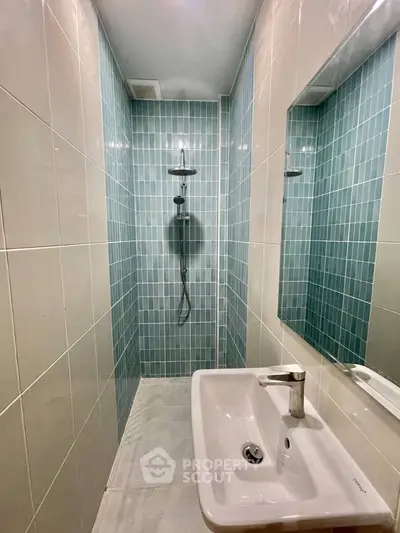 Modern minimalist bathroom with sleek shower and stylish sink in compact space.