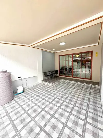 Spacious tiled patio with modern lighting and sliding glass doors, perfect for outdoor relaxation.