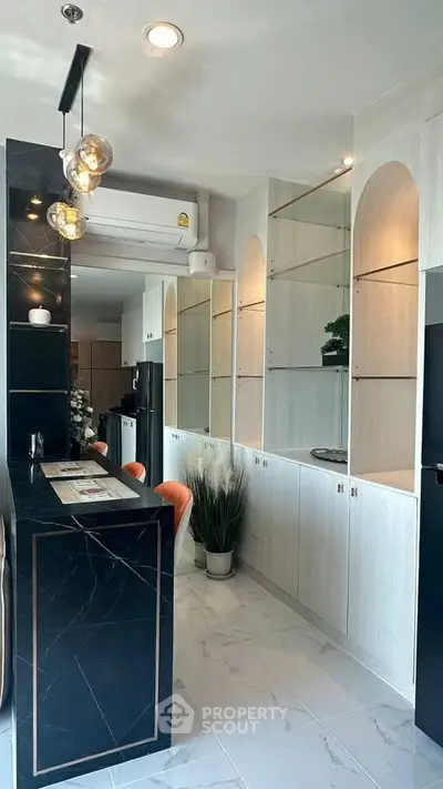 Modern kitchen with sleek black marble island and elegant lighting