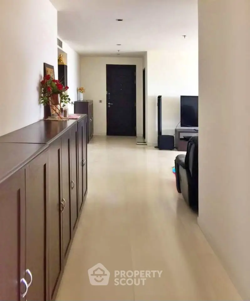 Spacious hallway leading to a cozy living room with modern furniture and elegant decor.