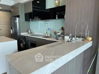 Modern kitchen with sleek design, featuring marble countertops and integrated appliances.