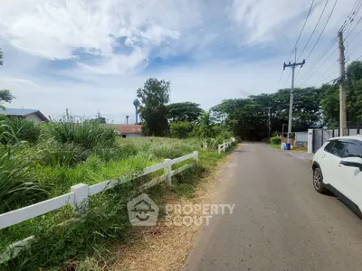 Scenic vacant land with lush greenery and road access, perfect for development.