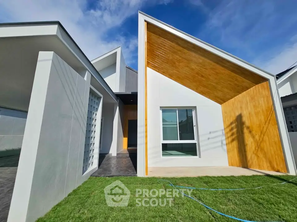 Modern architectural home exterior with unique geometric design and lush green lawn.