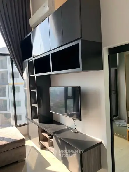 Modern living room with sleek black cabinetry and wall-mounted TV