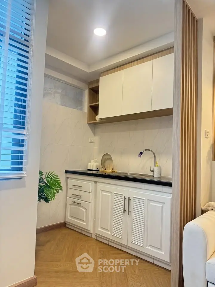 Charming compact kitchen with modern cabinetry and elegant wood flooring