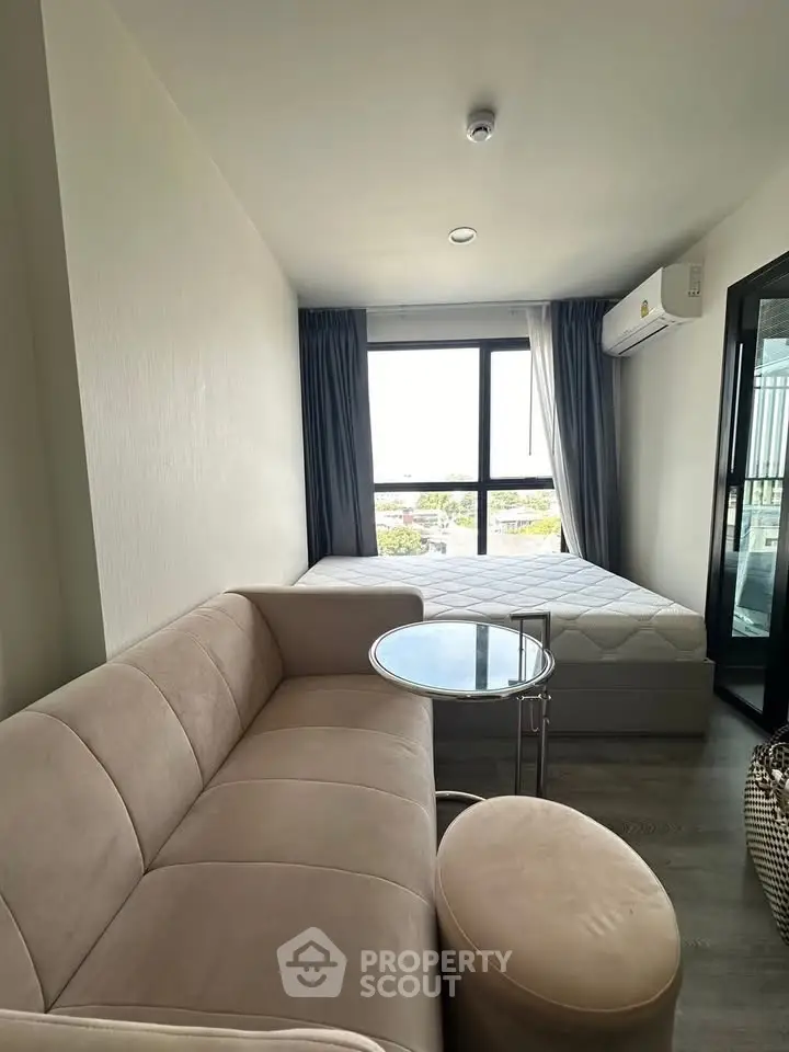 Modern studio apartment with cozy living area and large window view