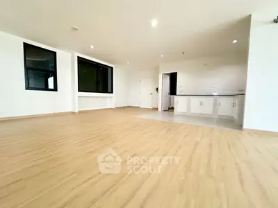 Spacious open-plan living area with modern kitchen and wooden flooring